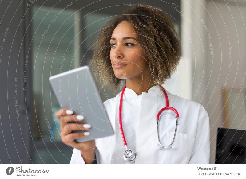 Portrait of young doctor with stethoscope and digital tablet looking at distance Occupation Work job jobs profession professional occupation work cloth
