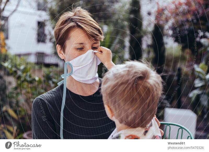 Littley boy helping his mother to put on a face mask human human being human beings humans person persons caucasian appearance caucasian ethnicity european 2