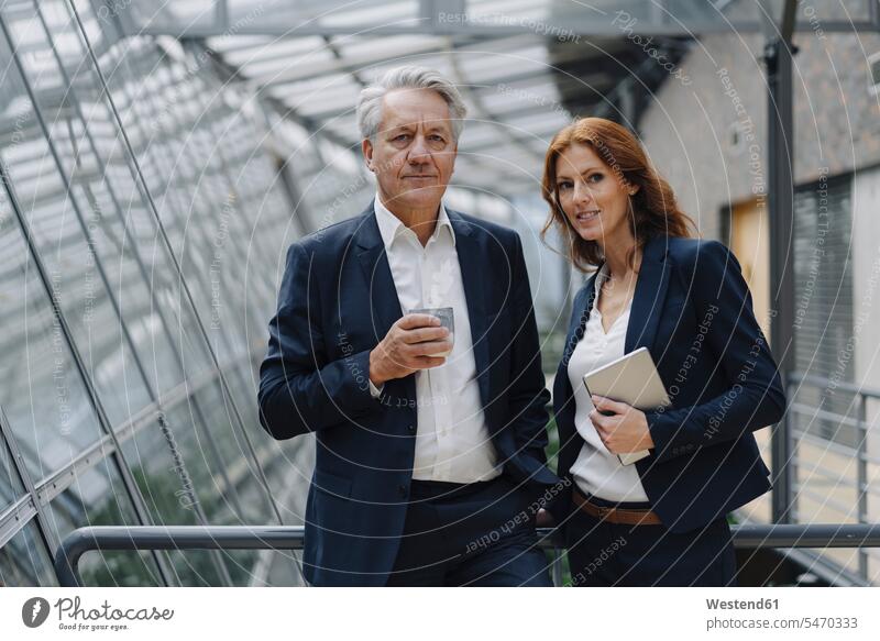 Portrait of confident businessman and businesswoman in modern office building human human being human beings humans person persons caucasian appearance