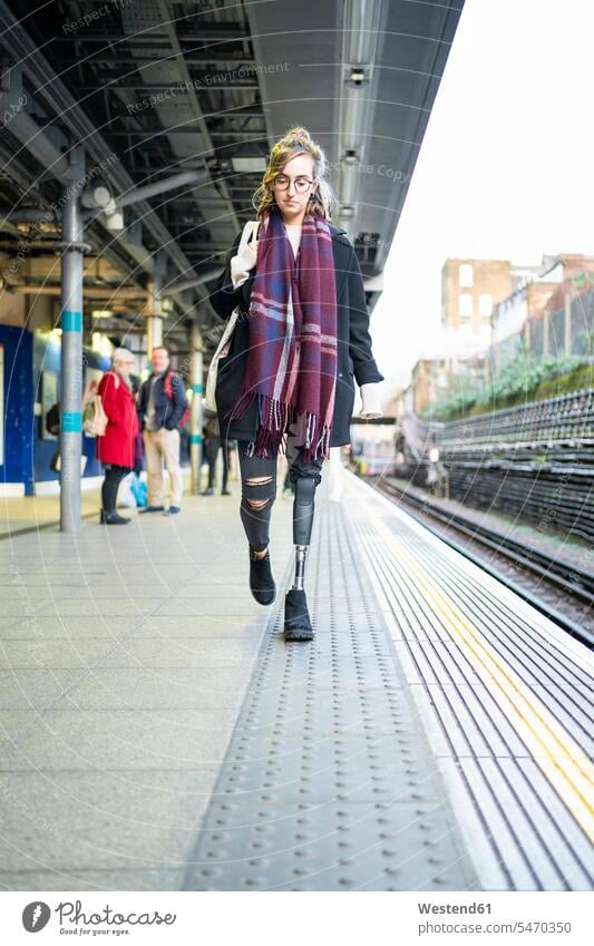 Young woman with leg prosthesis walking at station platfom human human being human beings humans person persons caucasian appearance caucasian ethnicity