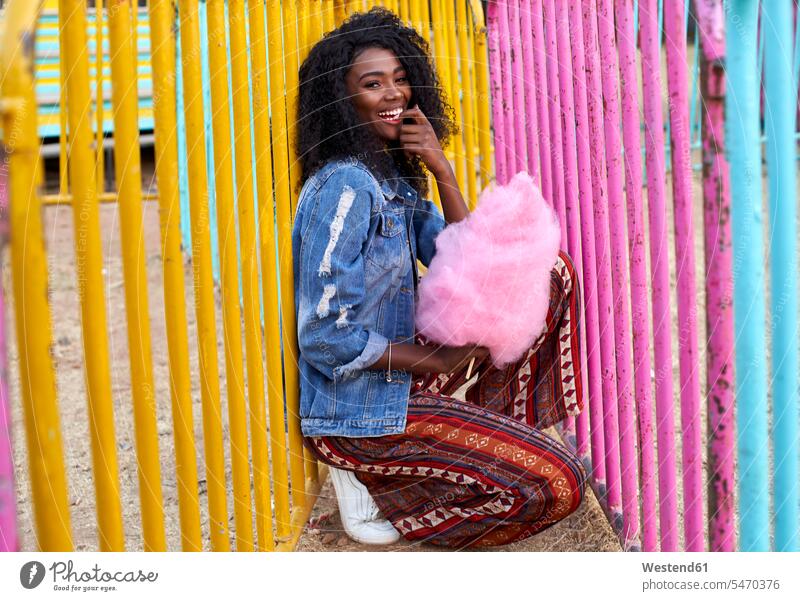 Portrait of happy young woman with pink candyfloss at fair human human being human beings humans person persons African black black ethnicity coloured 1