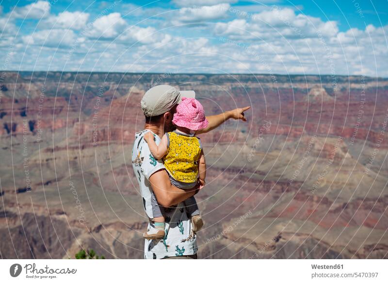USA, Arizona, Grand Canyon National Park, father and baby girl enjoying the view, rear view pointing point at pointing at infants nurselings babies View Vista