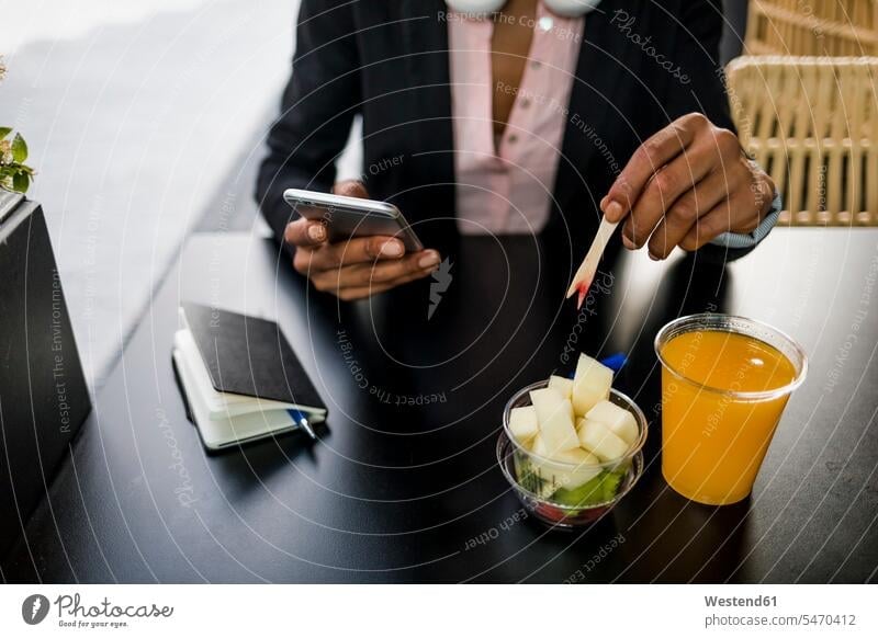 Businesswoman using cell phone at pavement cafe while eating fruit salad businesswoman businesswomen business woman business women Smartphone iPhone Smartphones