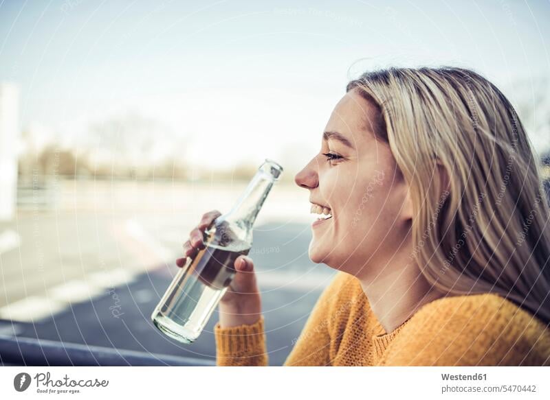 Profile of laughing young woman with soft drink Germany high spirits good mood refreshing drink soft drinks refreshing drinks getting away from it all