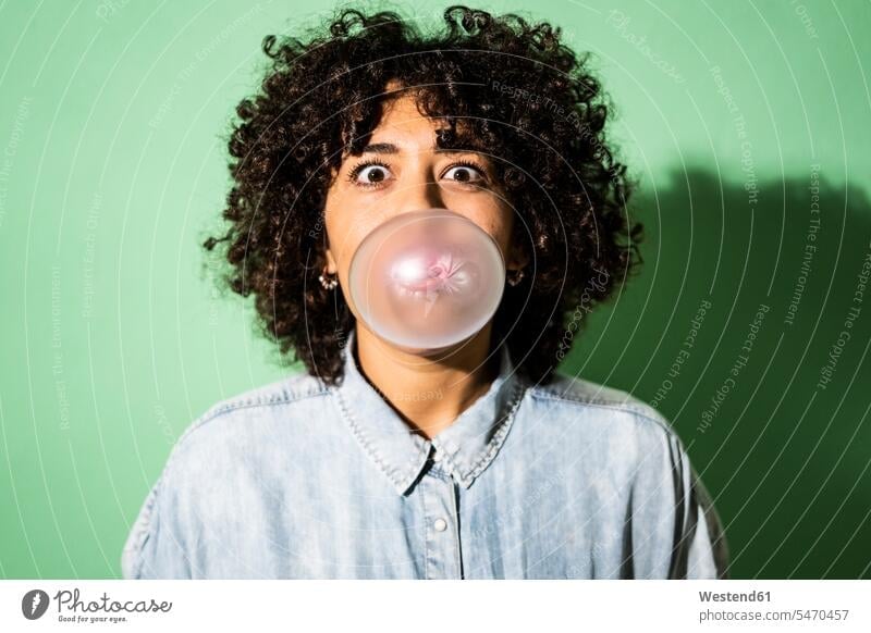 Portrait of young woman blowing bubble gum bubble studio shot studio photograph studio photographs studio shots indoors indoor shot indoor shots interior