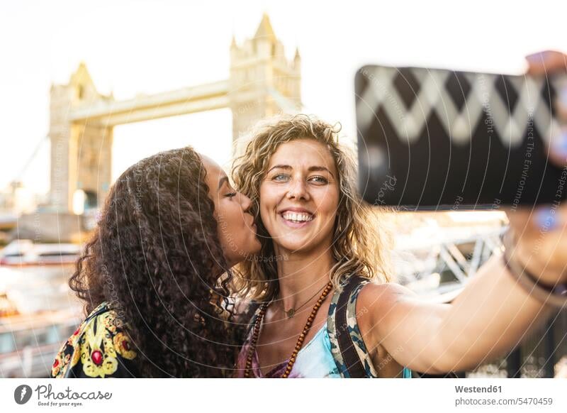 UK, London, two friends taking a selfie with Tower Bridge in background bridge bridges female friends woman females women happiness happy Selfie Selfies mate