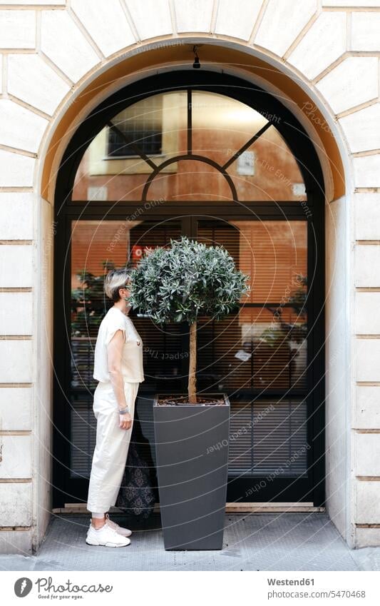 Woman hiding her head in a big potted plant in the city, Rome, Italy human human being human beings humans person persons caucasian appearance