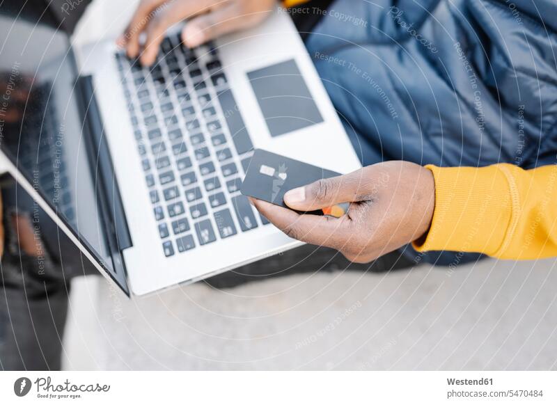 Close-up of man using laptop and credit card for online shopping finance financial credit cards debit card direct payment computers Laptop Computer