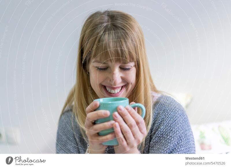 Portrait of laughing young woman with coffee mug Coffee Mug Coffee Mugs females women portrait portraits Laughter mugs cup Dishes Crockery Tableware Adults