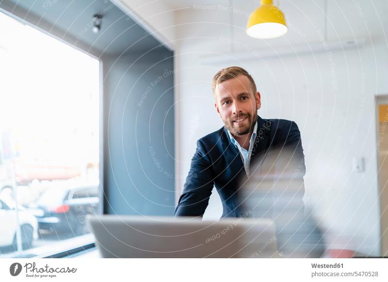 Portrait of smiling businessman with laptop in office human human being human beings humans person persons caucasian appearance caucasian ethnicity european 1