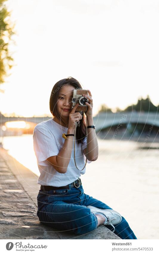 France, Paris, portrait of young woman with camera at river Seine at sunset females women River Rivers cameras portraits photographing smiling smile sunsets
