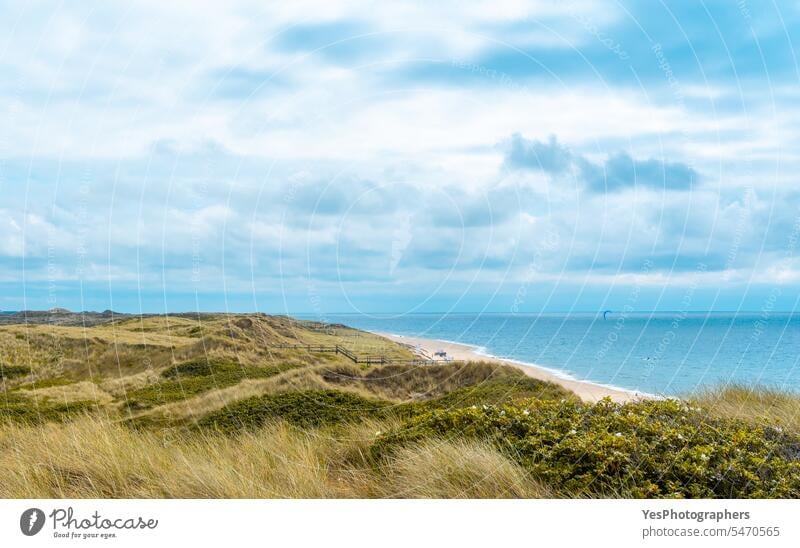 Landscape on Sylt island with the North Sea and the marram grass hills background beach beautiful blue bright cloudy coast coastline color dunes empty