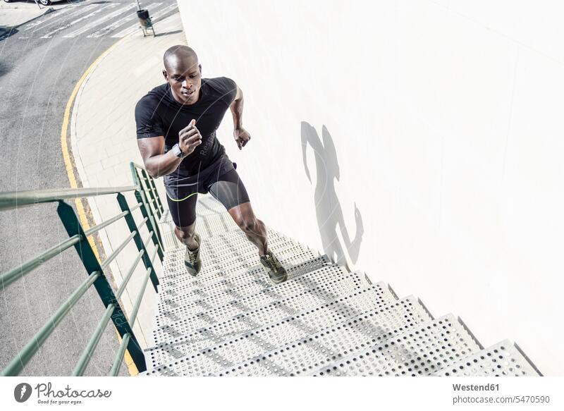 Man in black sportswear running up staircase stairs stairway upwards Sportswear Activewear Sport Clothes Sports Clothes Sports Wear Sports Clothing
