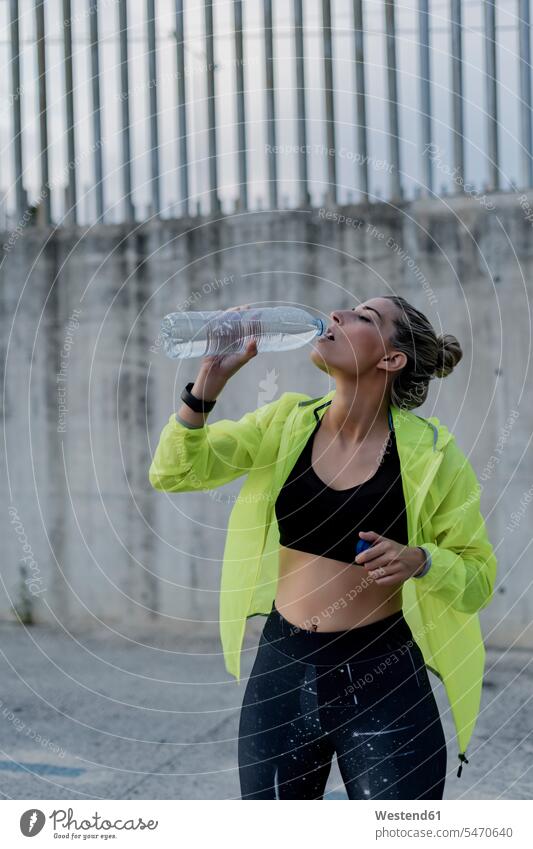 Sporty woman drinking from a water bottle watches wrist watches Wristwatch Wristwatches exercise practising train training stand Accomplish Accomplishment
