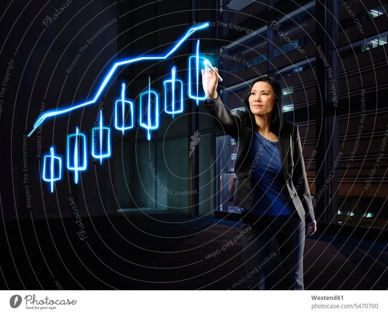 Asian businesswoman painting candle stick chart with light businesswomen business woman business women stock market stocks and shares financial market