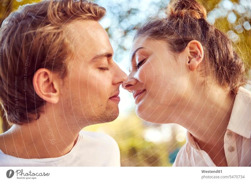 Young couple in love kissing at a park kisses parks twosomes partnership couples people persons human being humans human beings feeling nature natural world