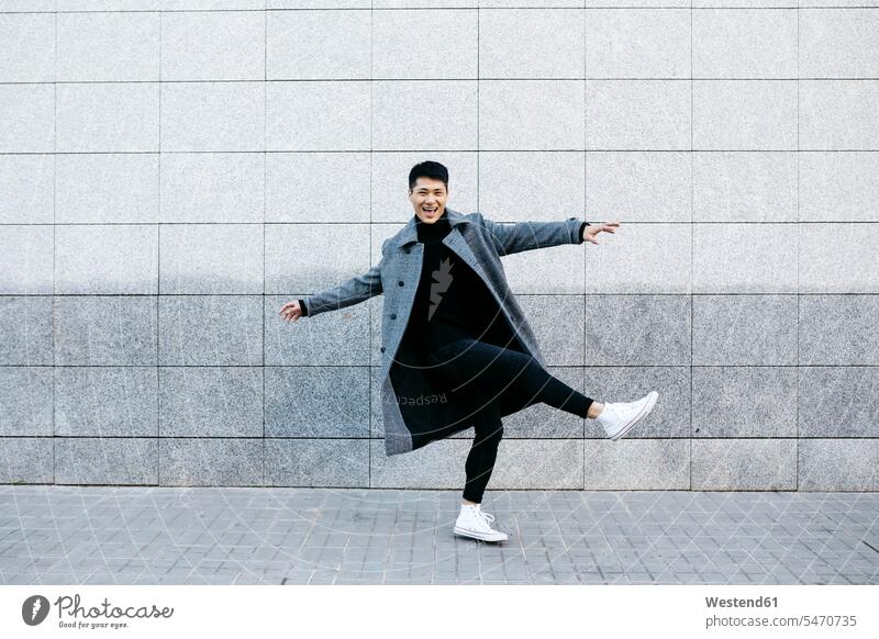 Stylish young man dancing on the street dance road streets roads wall walls men males style stylish Adults grown-ups grownups adult people persons human being
