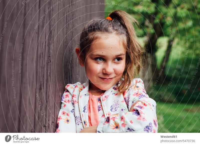 Portrait of smiling girl leaning against wooden wall portrait portraits wooden walls smile females girls child children kid kids people persons human being