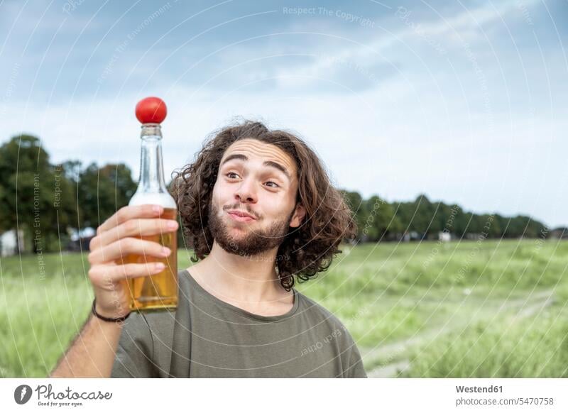 Portrait of smiling young man outdoors balancing tomato on beer bottle Beer Bottle Beer Bottles balance smile portrait portraits Tomato Tomatoes Balance