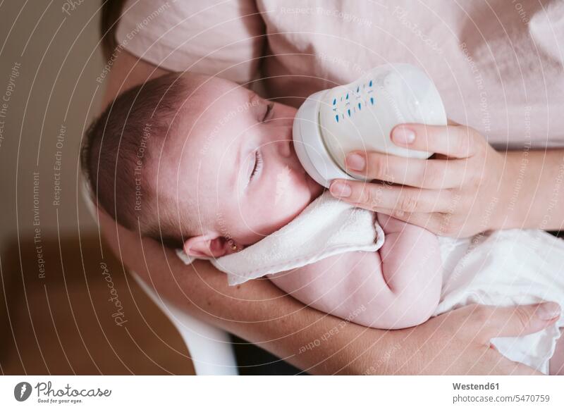 Mother bottle feeding baby girl at home color image colour image indoors indoor shot indoor shots interior interior view Interiors day daylight shot