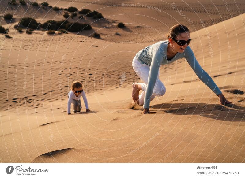 Mother and daughter crawling up sand dune, Gran Canaria, Spain touristic tourists Eye Glasses Eyeglasses specs spectacles Pair Of Sunglasses sun glasses relax