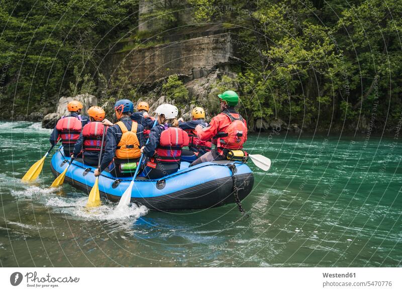 Group of people rafting in rubber dinghy on a river friends mate free time leisure time balanced Equilibrium protect protecting safe Safety secure funny