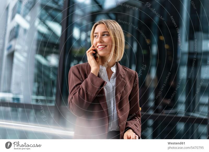 Smiling young businesswoman on the phone in the city business life business world business person businesspeople business woman business women businesswomen