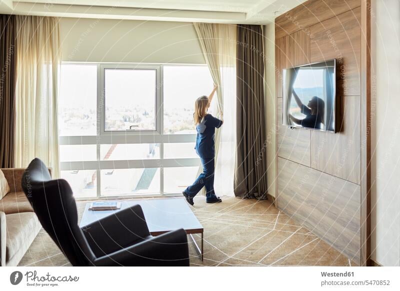 Chambermaid opening curtains of window in hotel bedroom color image colour image indoors indoor shot indoor shots interior interior view Interiors Millennials