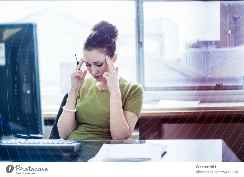 Frustrated female entrepreneur with head in hands in board room at office color image colour image indoors indoor shot indoor shots interior interior view