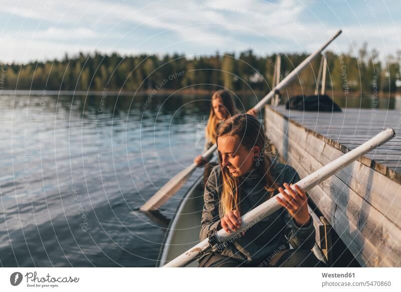 Two young women boating on lake human human being human beings humans person persons caucasian appearance caucasian ethnicity european 2 2 people 2 persons two