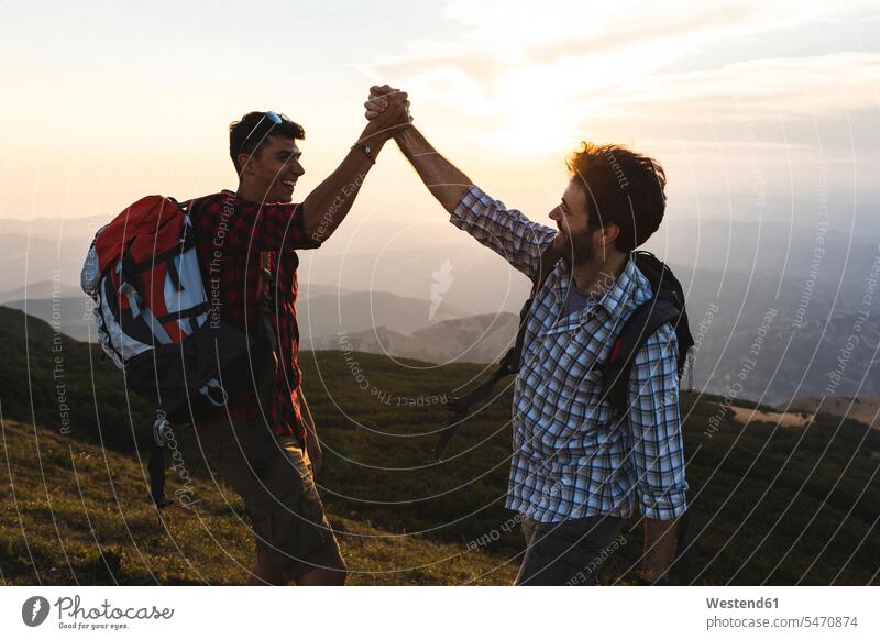 Italy, Monte Nerone, two happy and successful hikers in the mountains at sunset happiness wanderers mountain range mountain ranges sunsets sundown man men males