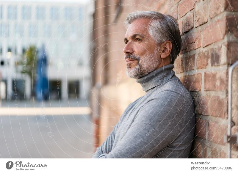 Portrait of mature businessman leaning at a brick wall human human being human beings humans person persons caucasian appearance caucasian ethnicity european 1