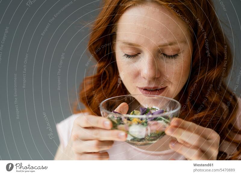 Portrait of redheaded woman smelling blossoms in glass bowl relax relaxing relaxation delight enjoyment Pleasant pleasure indulgence indulging savoring