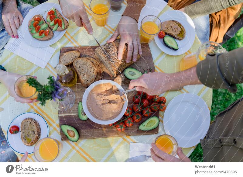 Close-up of friends enjoying a healthy vegan breakfast outdoors touristic tourists Drinking Glass Drinking Glasses Bowls dish dishes Plates Tables knives relax