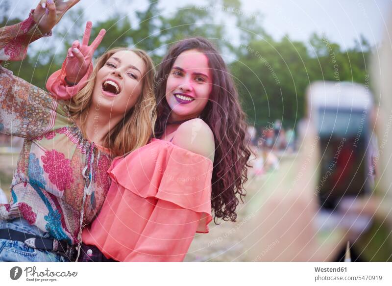 Portrait of happy women at the music festival, photographing peace sign peace signs symbol of peace peace symbol colour powder color powder colored powder