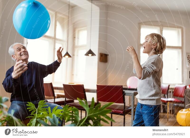 Happy grandfather and grandson playing with balloon at home generation balloons windows jumper sweater Sweaters fly smile Ardor Ardour enthusiasm enthusiastic