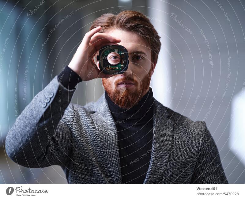 Portrait of businessman looking through an object in modern office human human being human beings humans person persons Middle Eastern 1 one person only