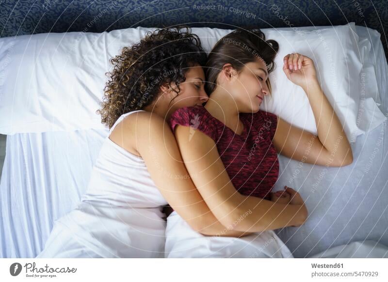 Lesbian couple sleeping on bed at home color image colour image indoors indoor shot indoor shots interior interior view Interiors day daylight shot