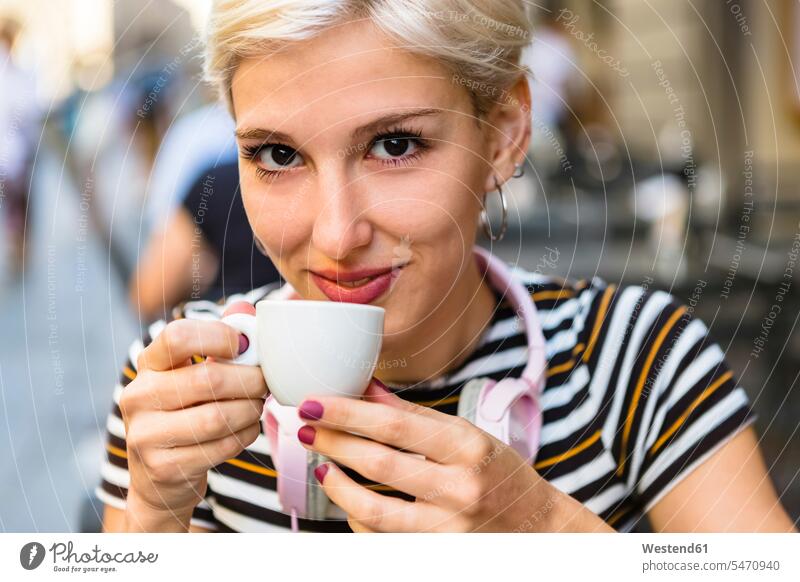Portrait of smiling young woman drinking espresso at pavement cafe Espresso outdoor cafes smile females women portrait portraits Coffee Drink beverages Drinks