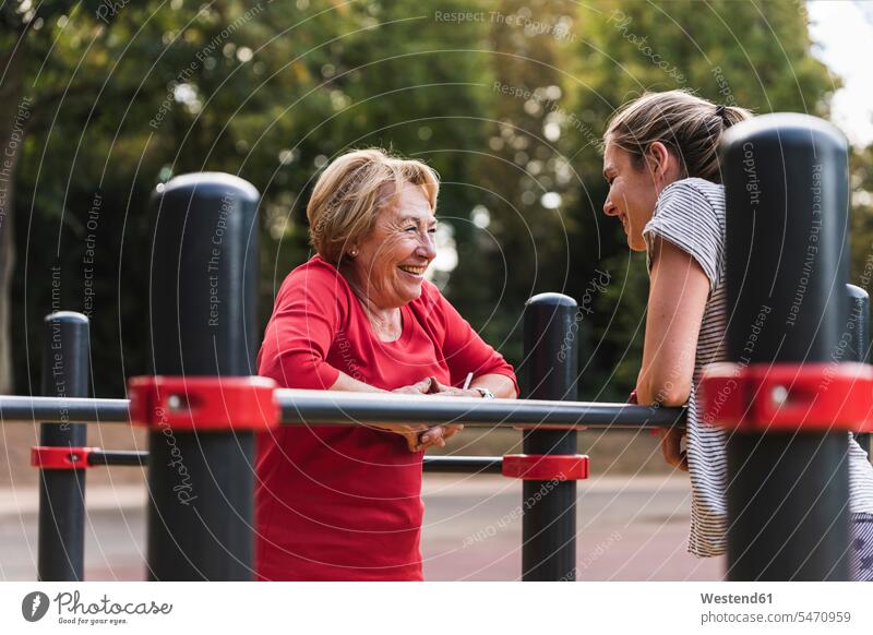 Grandmother and granddaughter training on bars in a park exercising exercise practising Strength strong Force Strengthy Power parks Flexibility flexible