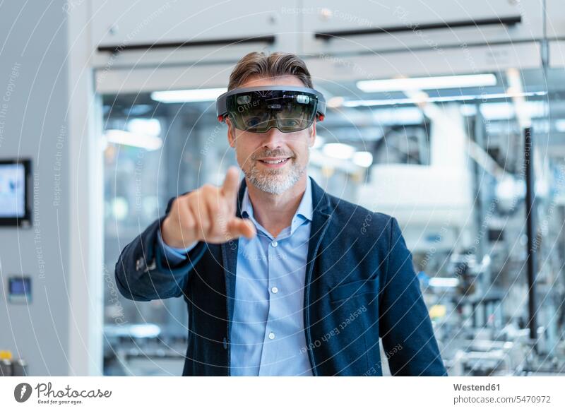 Smiling businessman wearing AR glasses in a modern factory human human being human beings humans person persons caucasian appearance caucasian ethnicity