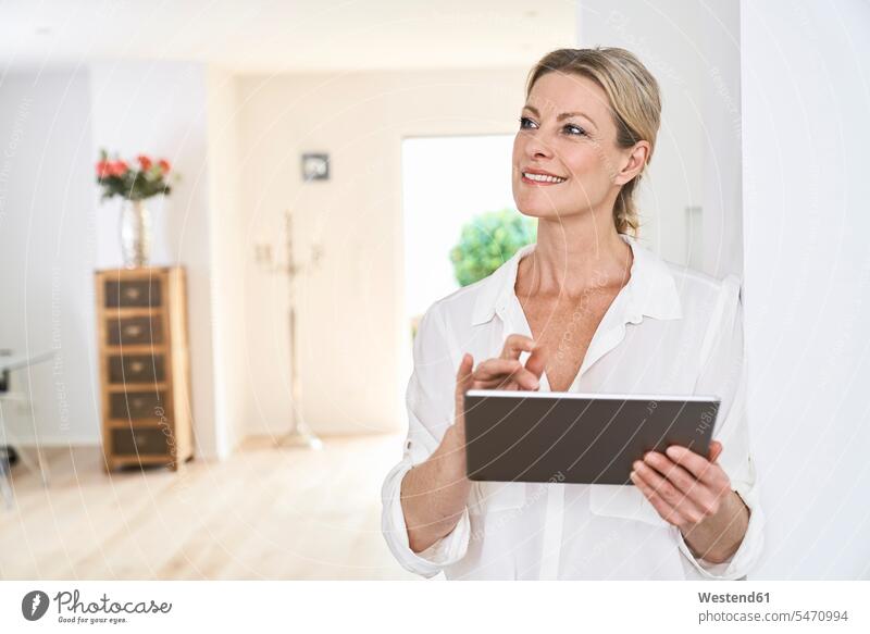 Smiling woman using tablet at home happiness happy females women white blouse blouses digitizer Tablet Computer Tablet PC Tablet Computers iPad Digital Tablet