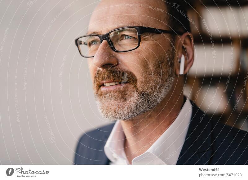 Portrait of mature businessman listening to music with bluetooth earbuds human human being human beings humans person persons caucasian appearance