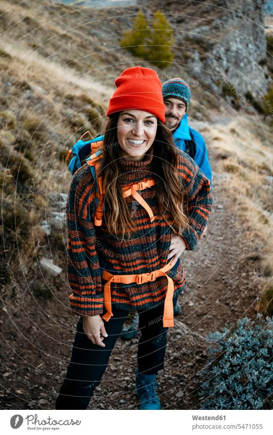 Smiling woman hiking with boyfriend on rocky mountain during vacation color image colour image outdoors location shots outdoor shot outdoor shots day