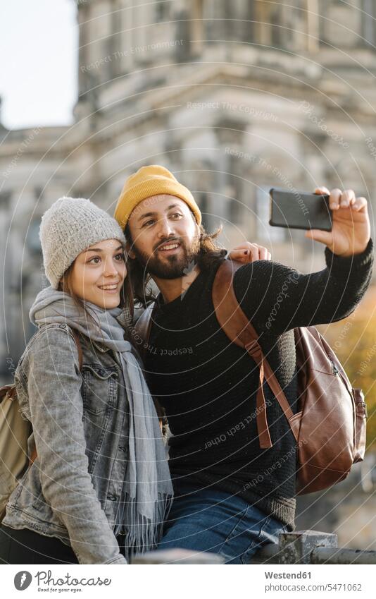 Young couple taking a selfie with Berlin Cathedral in background, Berlin, Germany touristic tourists back-pack back-packs backpacks rucksack rucksacks