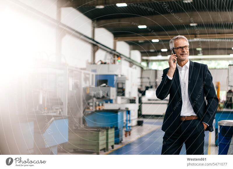 Manager talking on the phone in high tech company industry industrial Smartphone iPhone Smartphones firm using use call telephoning On The Telephone calling