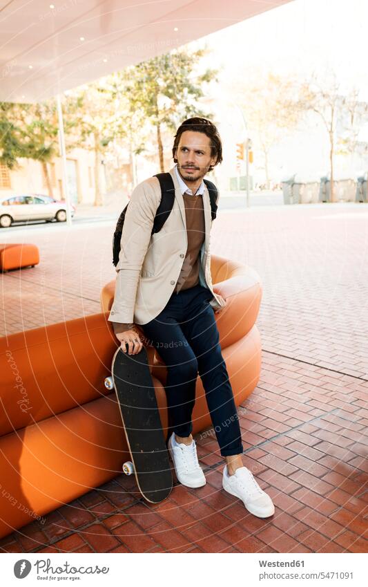Portrait of man with backpack and skateboard in the city rucksacks backpacks back-packs Skate Board skateboards portrait portraits men males town cities towns