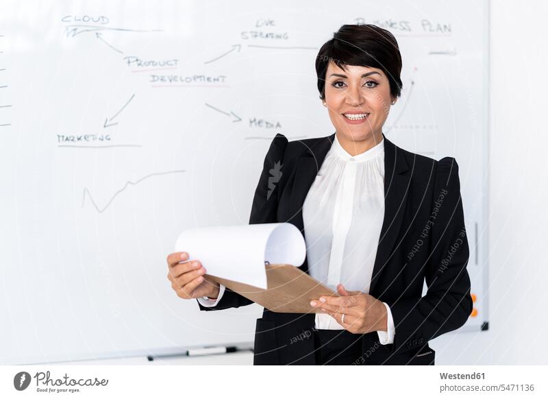 Portrait of businesswoman posing with documents in hands indoors indoor shot indoor shots interior interior view Interiors portrait portraits