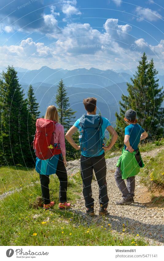 Germany, Bavaria, Brauneck near Lenggries, young friends standing in alpine landscape looking at view mountain range mountains mountain ranges View Vista