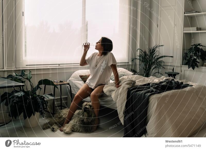 Mature woman sitting on bed in the morning drinking water human human being human beings humans person persons caucasian appearance caucasian ethnicity european